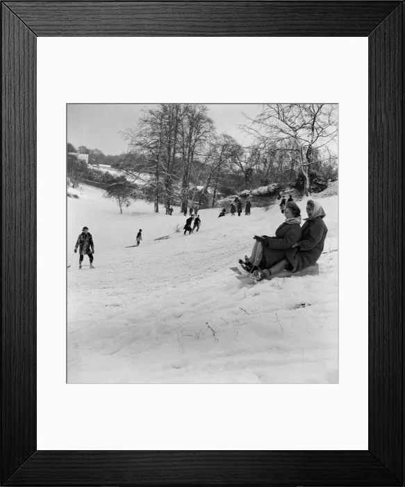 Framed Print : Why should the children only have fun, as two women take part in sledging in Stoke Park Framed Print : Why should the children only have fun, as two women take part in sledging in Stoke Park