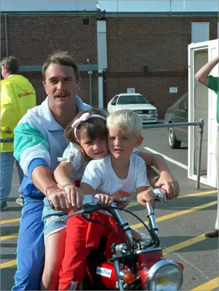 NIGEL MANSELL AND CHILDREN CHLOE MANSELL AND GREG MANSELL ON A BIKE AT THE FORMULA 1
