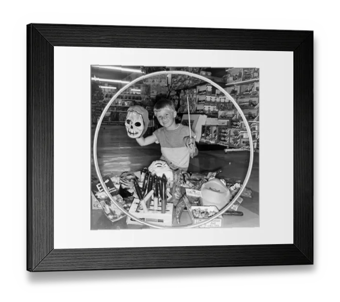 Framed Print : A boy surrounded by toys in a toy shop. July 1984