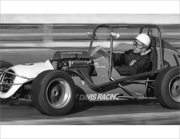 Stirling Moss rying out midget racing car at White City racing track - December 1971
