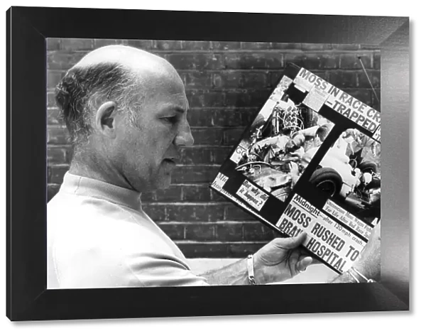 Stirling Moss reading clippings of his crash during race - August 1982