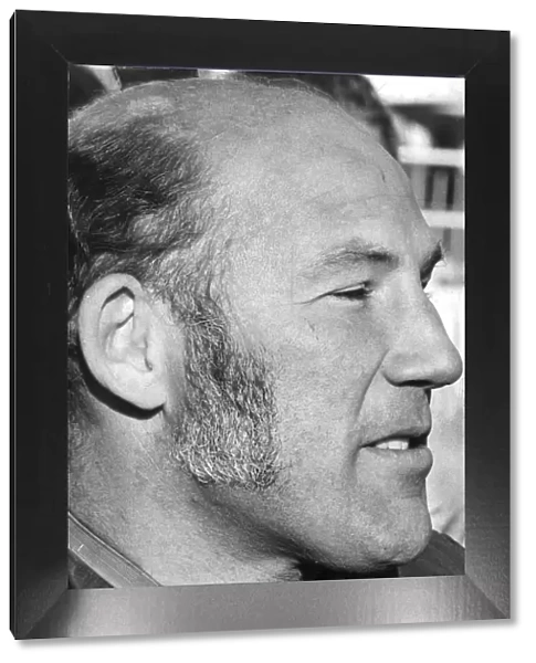 Stirling Moss in profile serious during interview at track - December 1971