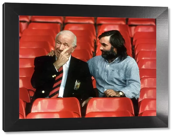 SIR MATT BUSBY AND GEORGE BEST SEATED IN FOOTBALL STANDS OF OLD TRAFFORD. 2  /  10  /  90