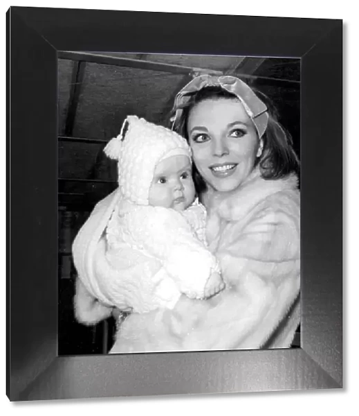 Joan Collins holding baby daughter Tara at London Airport - February 1964