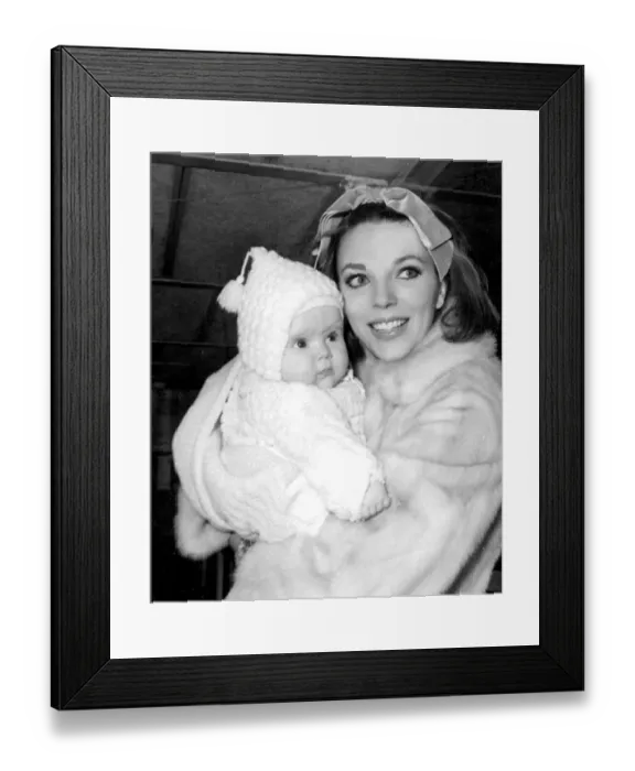 Framed Print : Joan Collins holding baby daughter Tara at London Airport - February 1964