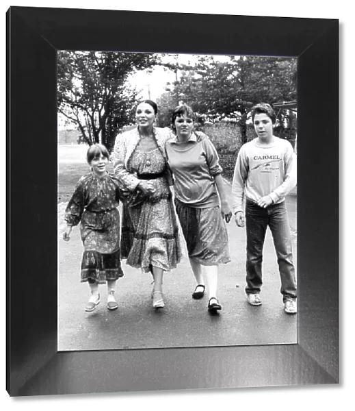Joan Collins with children Katyana Kass, Tara Newley and Sacha Newley walking in park