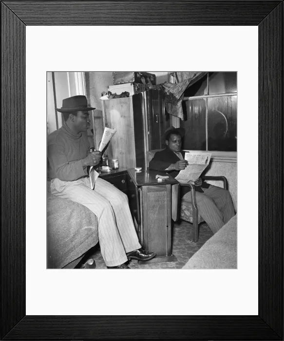 Framed Print : Young West Indian men in Brixton looking through the small ads in the local newspapers