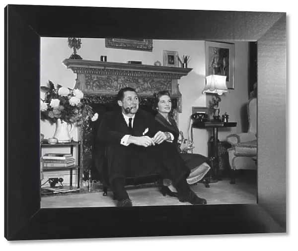 Anthony Quayle and wife Dorothy Hyson sitting by fire place of their London home - 24