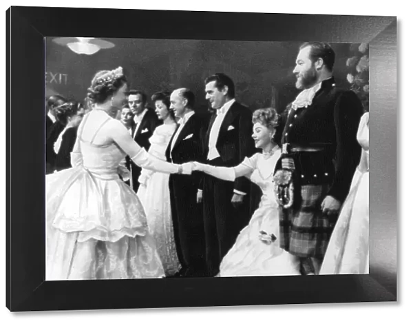 The Queen shaking hands with Glynis Johns watched by Kack Hawkins