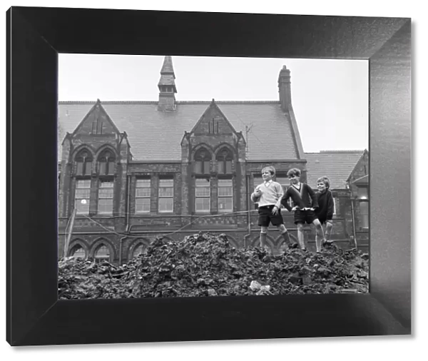 Pupils of Ross Place School, Ardwick, Manchester, jump across a sea of mud to enter