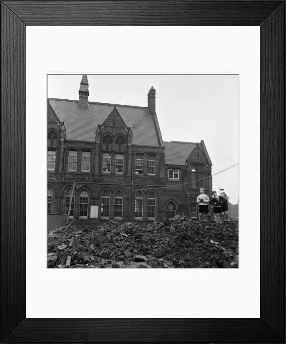 Framed Print : Pupils of Ross Place School, Ardwick, Manchester, jump across a sea of mud to enter Framed Print : Pupils of Ross Place School, Ardwick, Manchester, jump across a sea of mud to enter