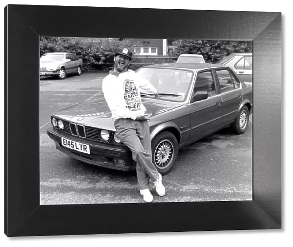 Kenny Everett sitting on bonnet of his new BMW car 21  /  07  /  1989