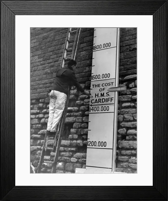 Framed Print : The man working on the indicator of Cardiffs Warship Week has to use an extension Framed Print : The man working on the indicator of Cardiffs Warship Week has to use an extension