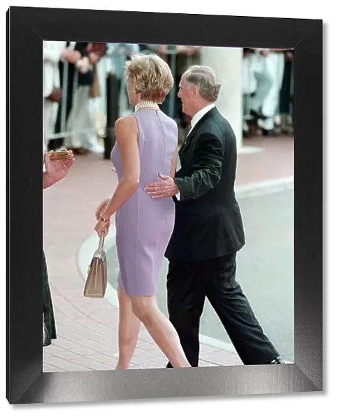 Princess Diana, wearing a purple dress is escorted to lunch by Australian dignitary Tom