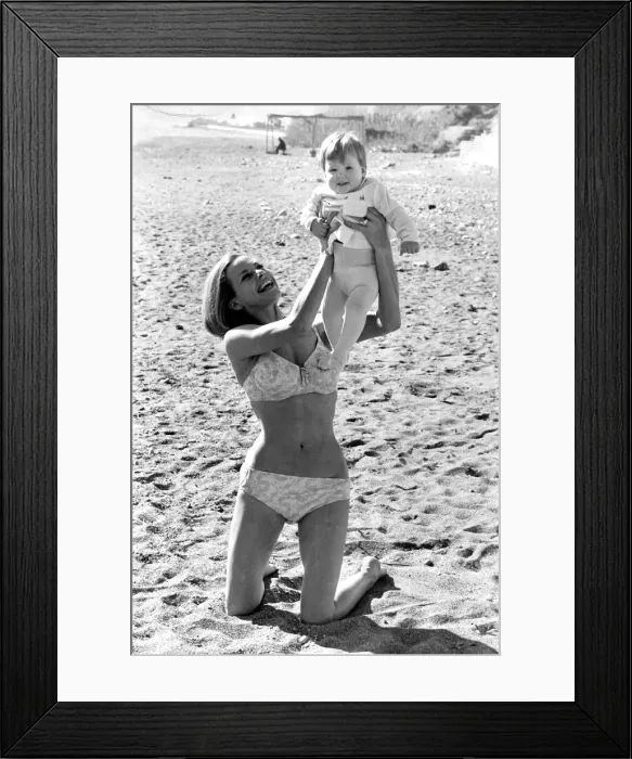 Framed Print : Honor Blackman wearing biini playing with daugher Lottie on beach in Spain during filming Framed Print : Honor Blackman wearing biini playing with daugher Lottie on beach in Spain during filming