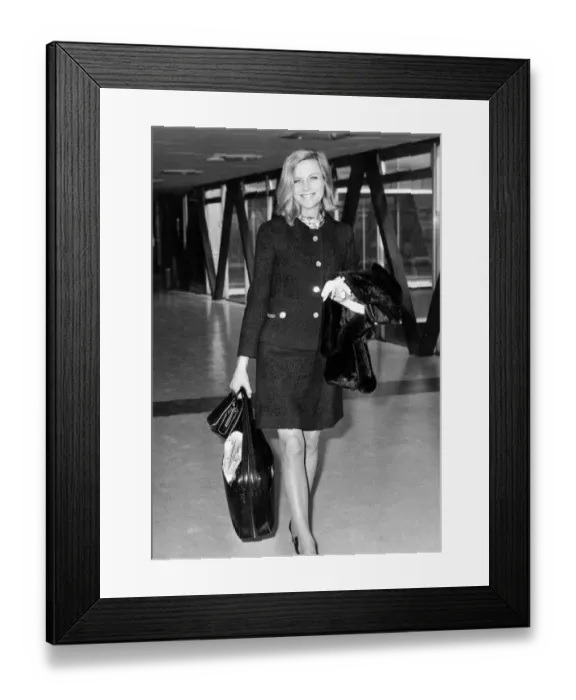 Framed Print : Honor Blackman wearing mini skirt two piece suit at London airport - April 1969