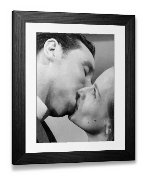 Framed Print : Honor Blackman kissing Patrick Macnee during filming of TV drama - January 1964