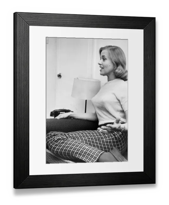 Framed Print : Honor Blackman interviewed kneeling on sofa wearing check slacks
