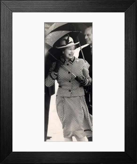 Framed Print : Queen Elizabeth II and Prince Philip pictured with umbrellas sheltering from the rain