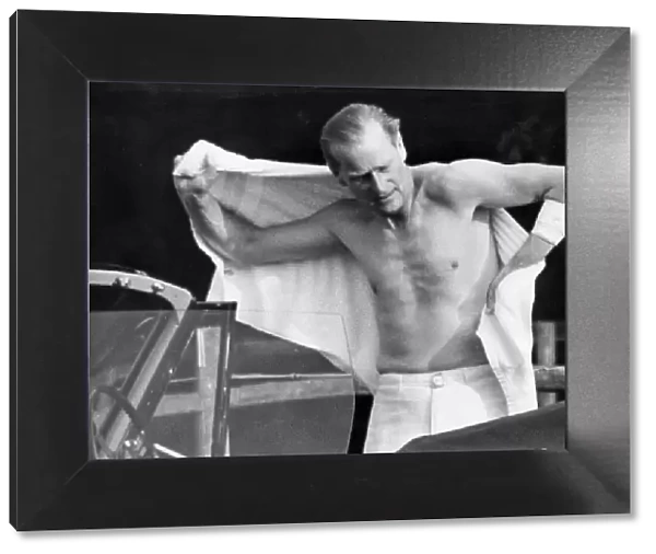 Prince Philip shirtless changing for polo. His arm bandaged up after injury. July 1963