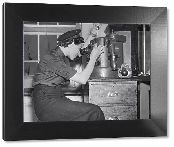 WRENS being trained to service submarines. Picture shows a WREN adjusting a part of