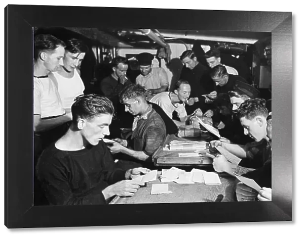 Some of the crew of HMS Minesweeper Commiles, adopted by the Daily Mirror reading their