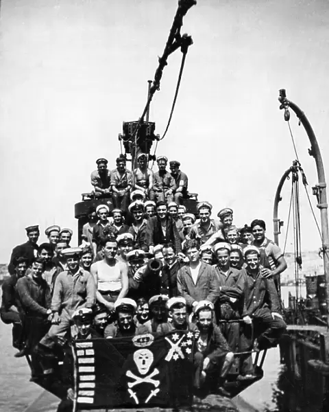 The crew of HMS Sportsman pose on the deck of their submarine at a un-named Northern