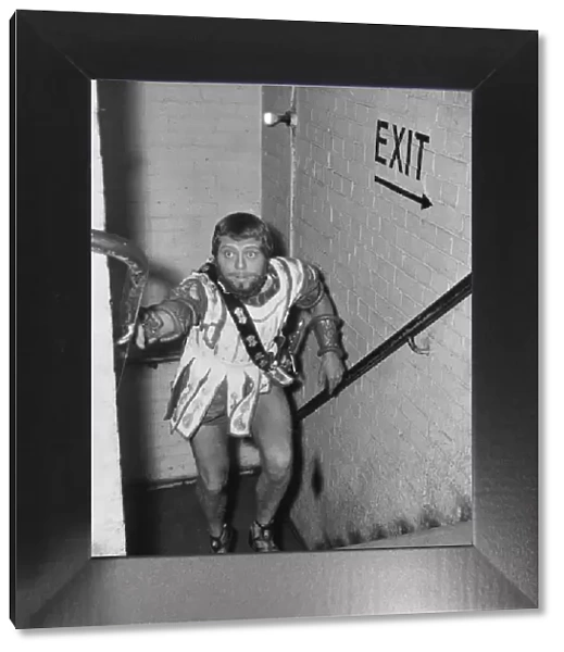 Richard Attenborough wearing Greek costume running up stairs backstage at the Piccadilly