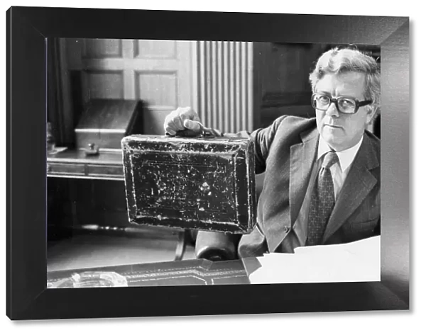 Sir Geoffrey Howe holding up budget box in his office at the Treasury - June 1979