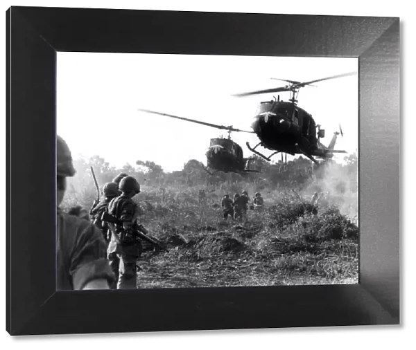 HUEY HELICOPTERS LAND IN FIELD DURING THE VIETNAM WAR TO PICK UP CASUALTIES SUSTAINED BY
