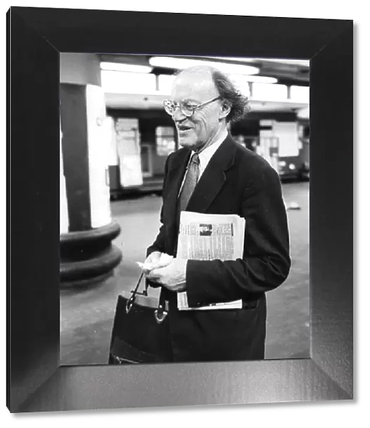Lord Frank Longford carrying copy of tabloid newspaper at Euston station
