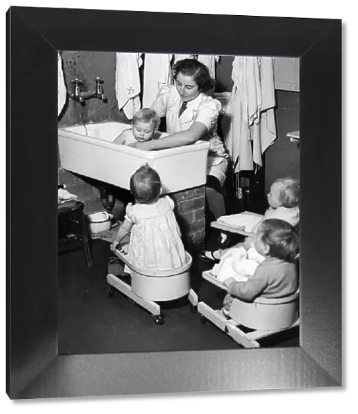 Salisbury day nursery. A woman bathing a child, with other seated children watching
