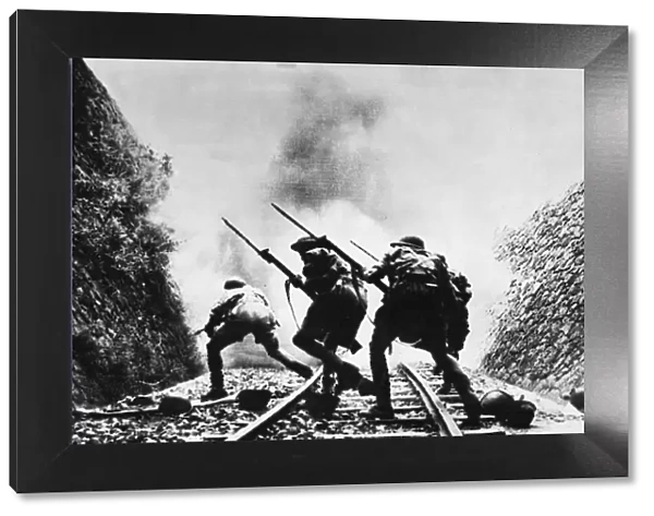 Soldiers of the British Eighth Army charge through a railway cutting with fixed bayonets