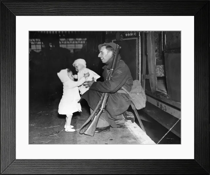 Framed Print : Home on Leave for Christmas. 1942. A soldier gives his daughter a doll Framed Print : Home on Leave for Christmas. 1942. A soldier gives his daughter a doll