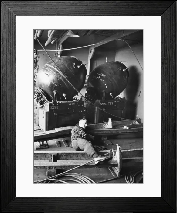 Framed Print : Mines that will be laid to trap enemy ships. A hard working man takes a well earned