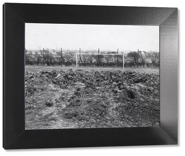 A thirty foot crater caused when a high explosive bomb dropped on a football pitch in