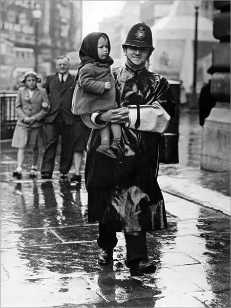 VJ Day, a policeman carries a lost child in Trafalgar Square, London. 15th August 1945
