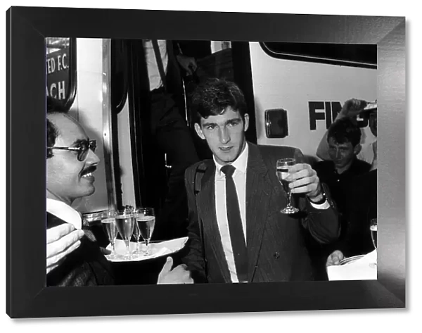 Norman Whiteside of Manchester United raises a glass after getting of the team coach