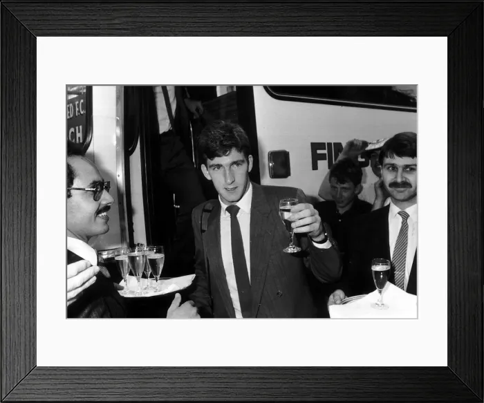 Framed Print : Norman Whiteside of Manchester United raises a glass after getting of the team coach Framed Print : Norman Whiteside of Manchester United raises a glass after getting of the team coach