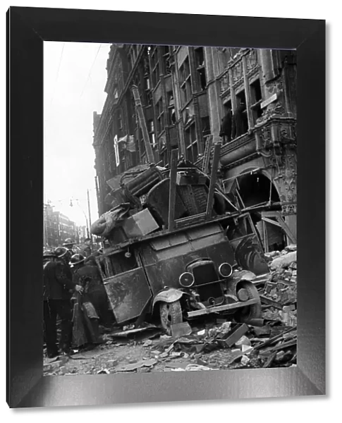 A van being loaded with furniture moving items from a bombed building is covered by