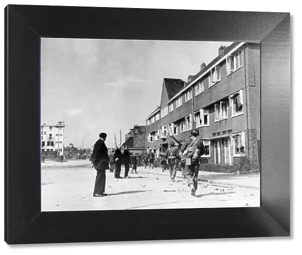 Civilians watch Canadian troops pass through Groningen, Netherlands, after its liberation