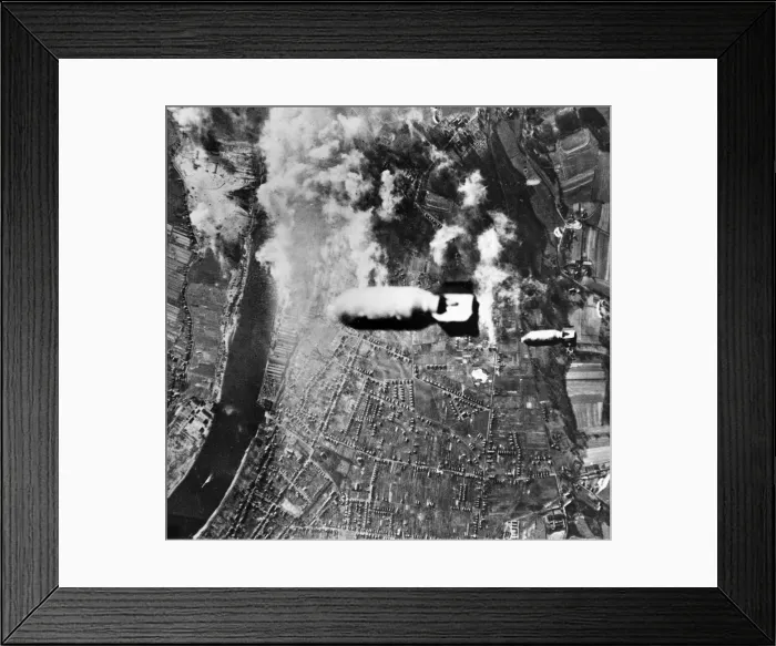 Framed Print : Two bombs drop from a US heavy bomber towards U-boat yards in the German district of Framed Print : Two bombs drop from a US heavy bomber towards U-boat yards in the German district of