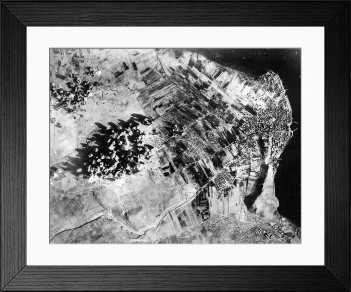 Framed Print : Administration buildings, hangers and revetments are covered by bomb bursts during a Framed Print : Administration buildings, hangers and revetments are covered by bomb bursts during a