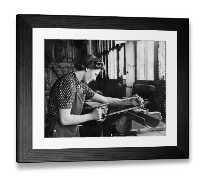 Framed Print : A lady working in a munitions factory. She is using what looks to be a bow saw