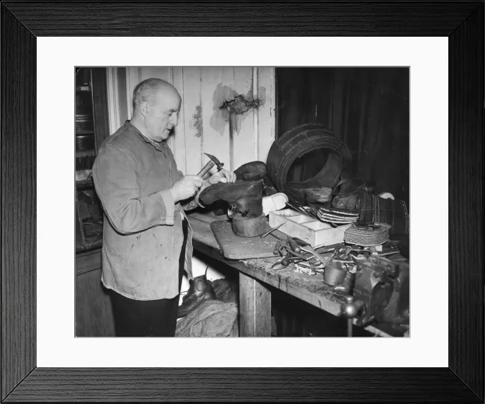 Framed Print : A cobbler at work. He is making boots - perhaps army boots Framed Print : A cobbler at work. He is making boots - perhaps army boots