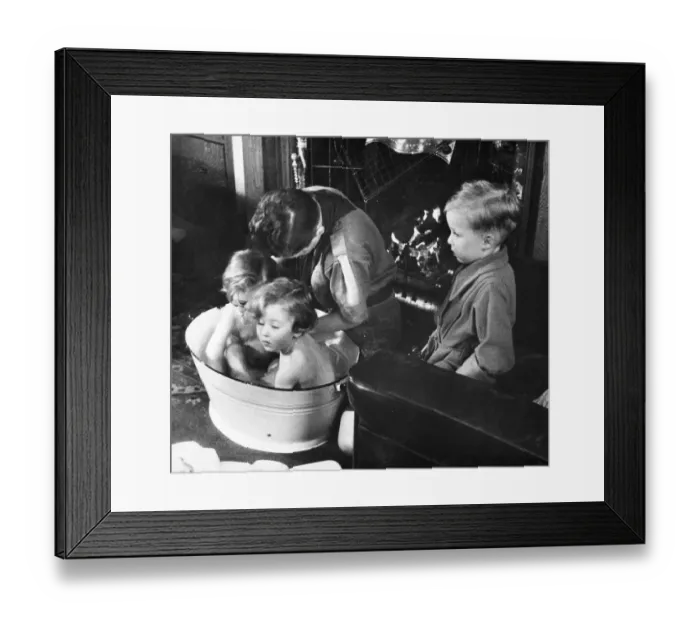Framed Print : Picture shows a boy scout bathing a baby. Newcastle. Tyne and Wear