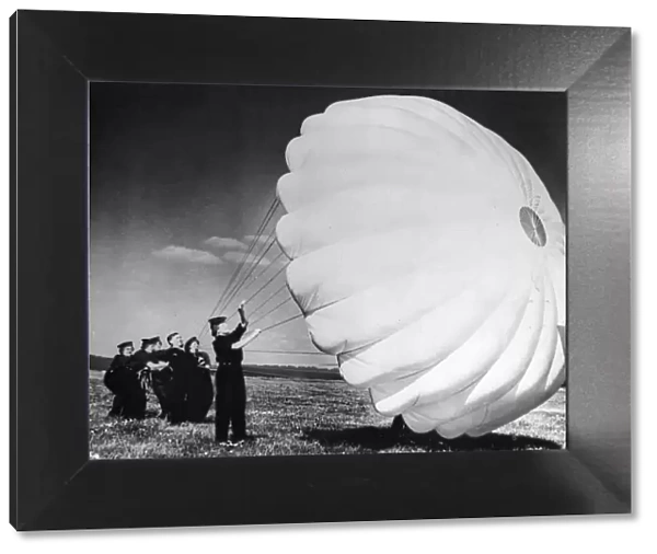 Parachute packers of the W. R. N. S. testing a parachute at a British Naval Air Station
