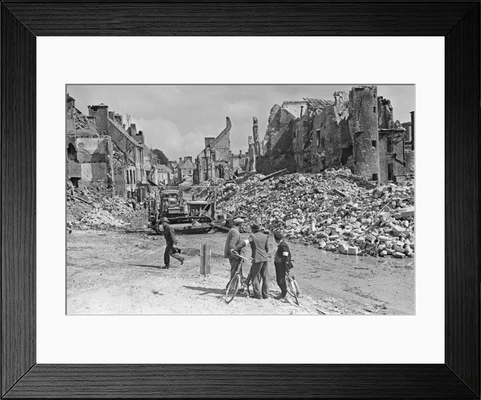 Framed Print : Ruined buildings and wrecked German transport in the streets of Montebourg as a result of