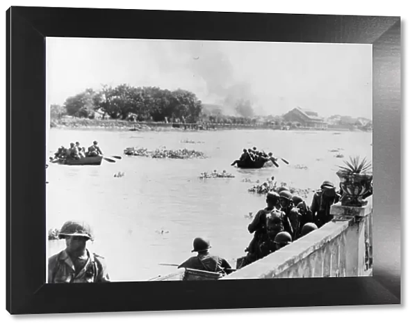 American Army troops cross the Pasig River which bisects Manila
