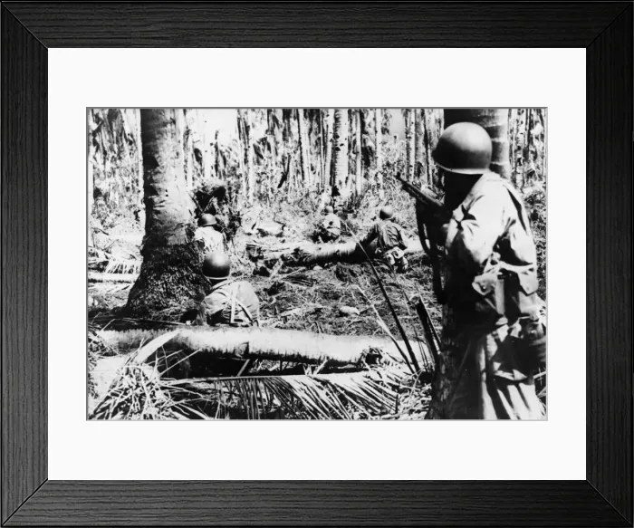 Framed Print : Cautiously, their guns ready for quick action, American troops push through the heavy